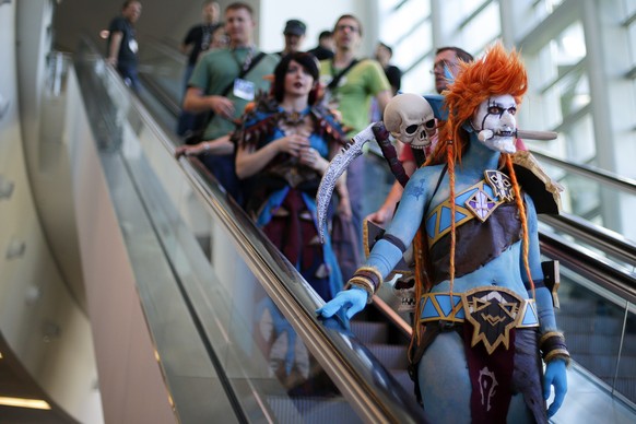 A woman dressed as Voljin from the video game World of Warcraft rides an escalator at the BlizzCon, Friday, Nov. 6, 2015, in Anaheim, Calif. &quot;World of Warcraft&quot; maker Blizzard is hosting its ...