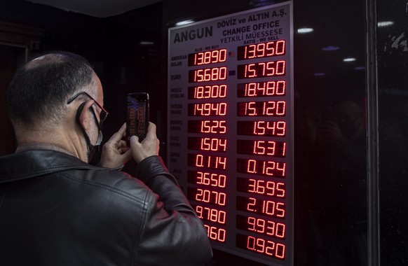 epa09635980 A man takes a picture of the currency board at an exchange office in Istanbul, Turkey, 11 December 2021. Turkish President Tayyip Erdogan appointed Nureddin Nebati, a strong supporter of t ...