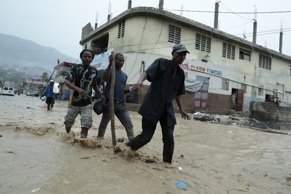 Residents wade through a flooded street after a heavy downpour in Port-au-Prince, Haiti, Saturday, June 3, 2023. (AP Photo/Odelyn Joseph)