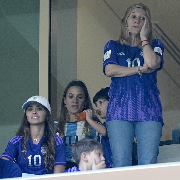 The mother of Lionel Messi Celia Maria Cuccittini, center, and his wife Antonela Roccuzzo, seated at left, wait for the start of the World Cup final soccer match between Argentina and France at the Lu ...
