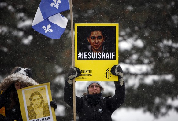 epaselect epa04593971 A woman holds a sign in support of Saudia Arabian blogger Raif Badawi during a march on Parliament Hill in Ottawa, Canada, 29 January 2015, calling for Badawi&#039;s release. Bad ...