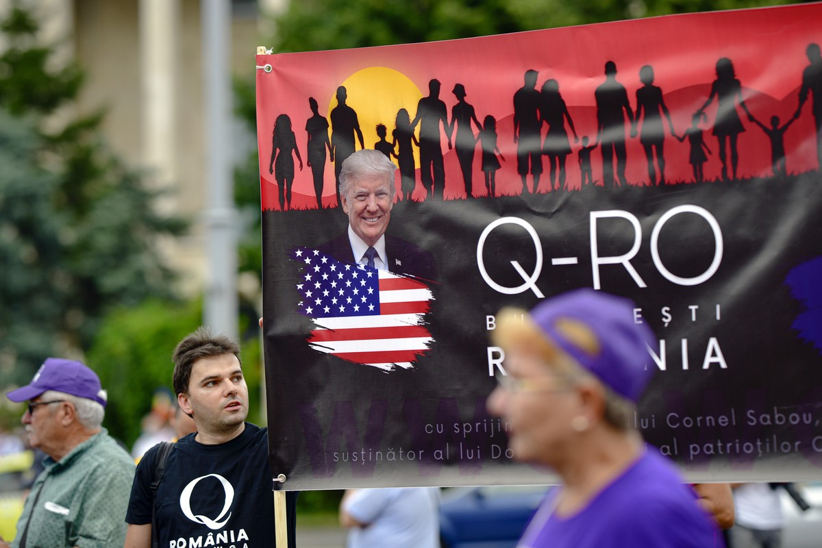 Romanian supporters of QAnon take part in a rally against the government's measures to prevent the spread of COVID-19 infections, like wearing a face mask, in Bucharest, Romania, Monday, Aug. 10, ...