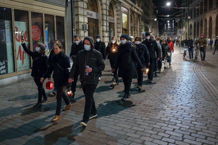 Fasnaechtler ziehen mit Mundschutz und Kerzen durch die Gassen am nicht stattfindenden Morgestraich in Basel, am Montag Morgen um 04:00 Uhr, am 2. Maerz 2020. Die Behoerden hatten die Drey scheenschte ...