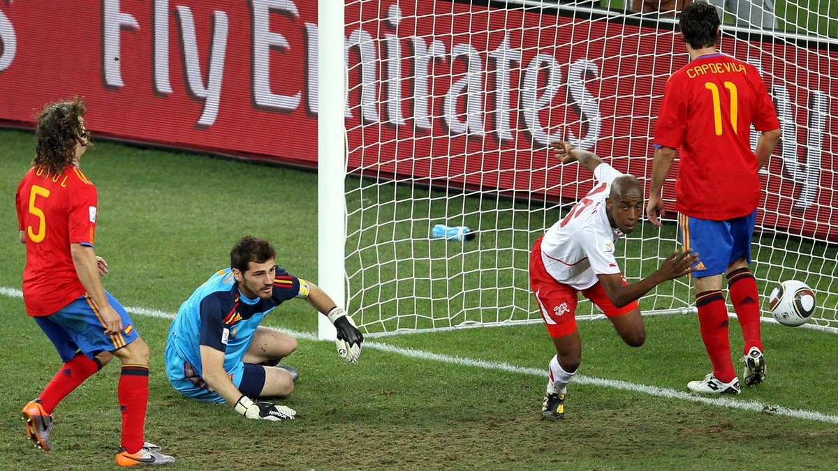 epa02205289 Swiss Gelson Fernandes (2nd R) celebates in front of Spain's goalkeeper Iker Casillas and defenders Gerard Pique (L), Carles Puyol (2nd L) and Joan Capdevila (R) after scoring the 1-0 ...