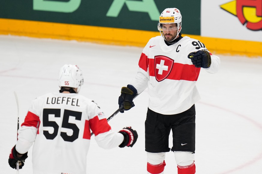 Switzerland&#039;s Roman Josi, right, celebrates with Switzerland&#039;s Romain Loeffel after scoring his sides second goal during the preliminary round match between Austria and Switzerland at the Ic ...