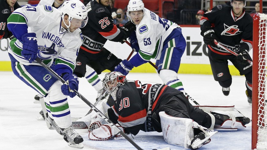 Vancouver Canucks&#039; Sven Baertschi (47), of Switzerland, shoots past Carolina Hurricanes goalie Cam Ward (30) to score during the first period of an NHL hockey game in Raleigh, N.C., Tuesday, Dec. ...