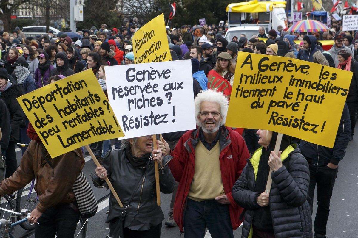 Des manifestants portant des pancartes defilent dans les rues genevoises, lors de la manifestation pour le droit a la Ville, ce samedi 17 mars 2018 a Geneve. (KEYSTONE/Salvatore Di Nolfi)