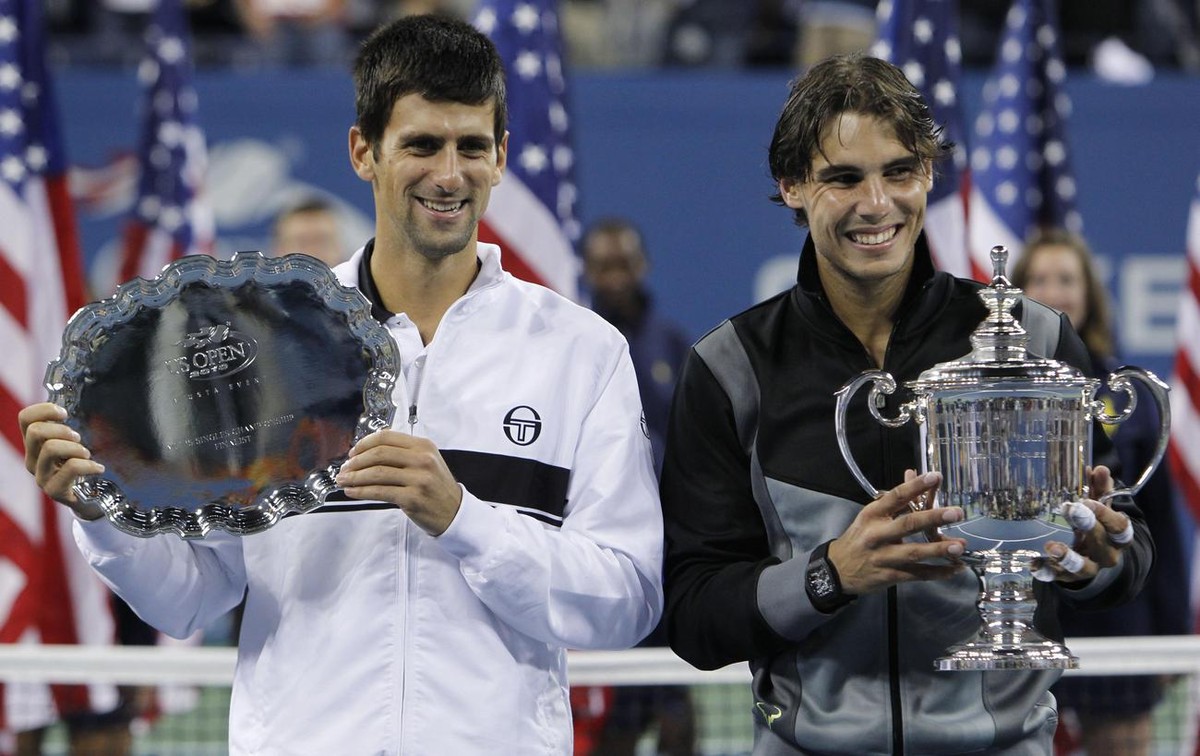 Rafael Nadal, right, of Spain, and Novak Djokovic of Serbia, pose with their trophies after Nadal beat Djokovic to win the men's championship match at the U.S. Open tennis tournament in New York, ...