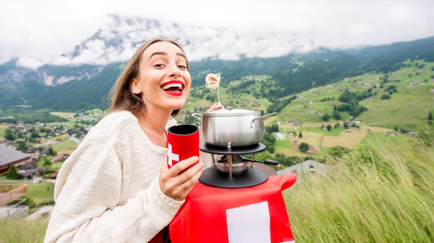 fondue essen frau schweiz bergen schweizerkreuz flagge