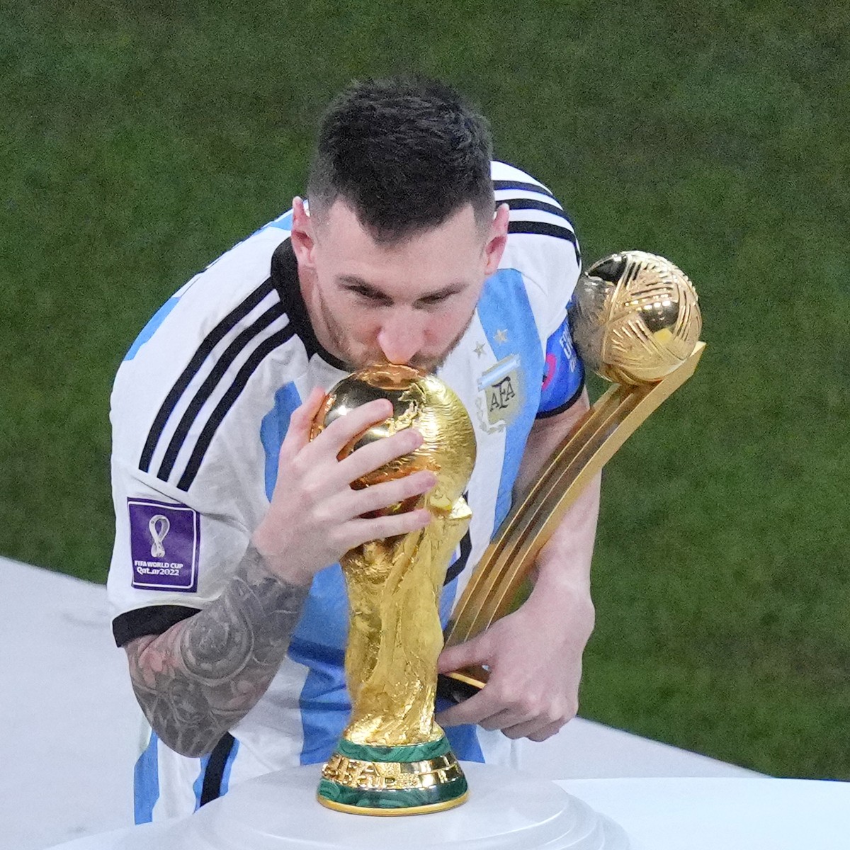 Argentina's Lionel Messi, holding the Golden Ball award for best player of the tournament, kisses the World Cup trophy at the end of the World Cup final soccer match between Argentina and France  ...
