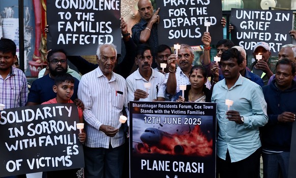 epa12175351 Indian people hold candles for the people who lost their lives in the Air India flight crash in Ahmedabad, during a candlelight vigil in Bangalore, India, 14 June 2025. Air India flight AI ...