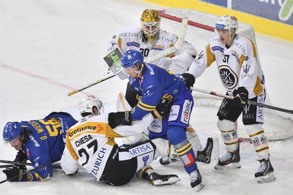 Der Davoser Magnus Nygren, oben, der Luganesi Alessandro Chiesa, unten, und HC Lugano Torhueter Elvis Merzlikins, geraten sich in die Haare, beim Eishockey-Qualifikationsspiel der National League A zw ...