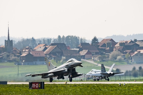 epa07501648 An Airbus Eurofighter jet takes off next to a Swiss Air Force F/A-18 Hornet during the press conference on a test day at the Swiss Army airbase, in Payerne, Switzerland, 12 April 2019. EPA ...