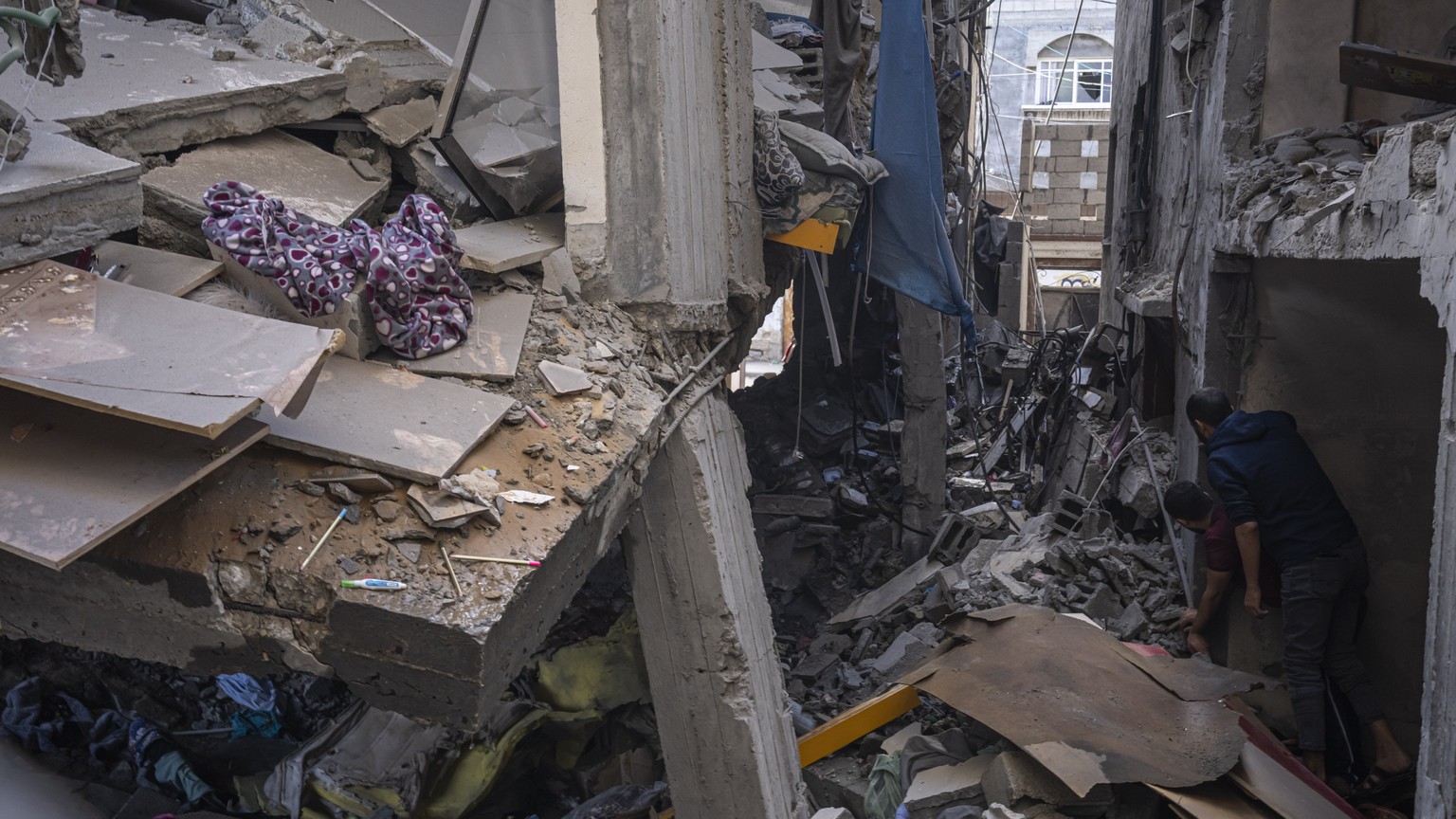 Palestinians inspect damage to their building following Israeli airstrikes on a house of an Islamic Jihad commander in Gaza City, Tuesday, May 9, 2023. The Israeli military says it has killed three se ...