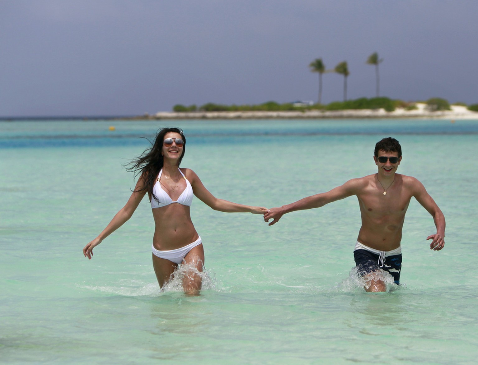 A Russian couple on their honeymoon runs in the lagoon of Paradise island resort in Male atoll, Maldives, Tuesday, Feb. 14, 2012. The Maldives, an Indian Ocean island nation that relies on high-end to ...