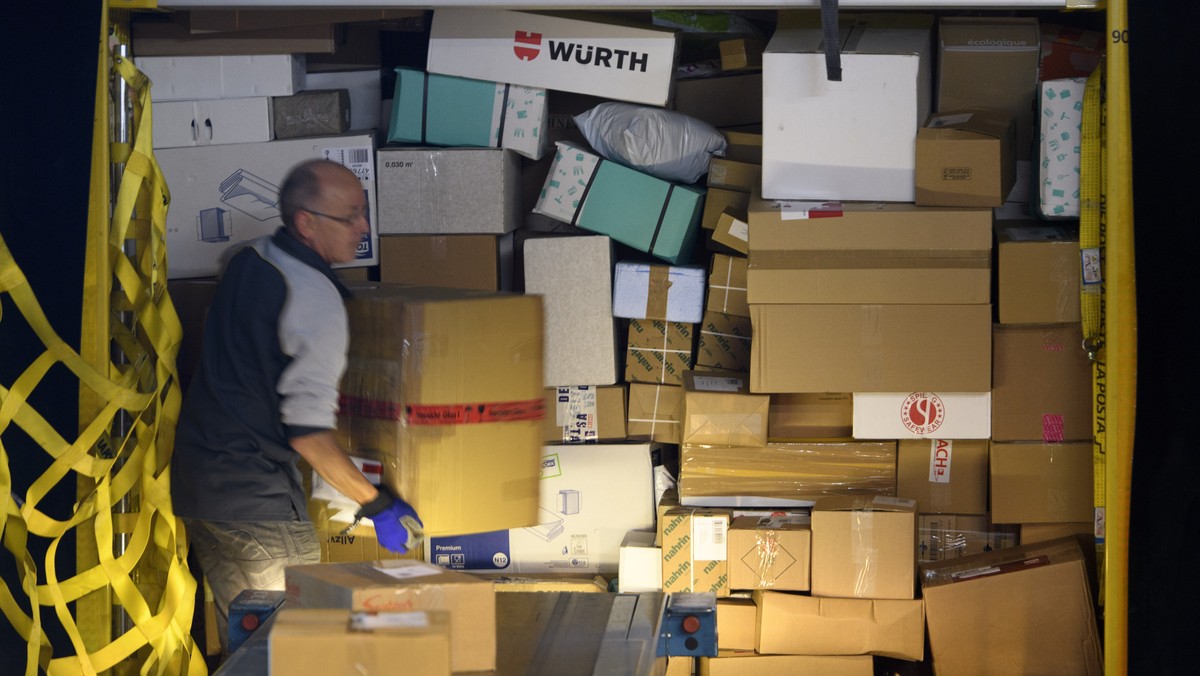 Un employe de la poste suisse decharge des paquets d'un container ce mardi 20 septembre 2016 au centre colis de Daillens, Vaud. La Poste a equipe le centre colis de Daillens d'une installati ...