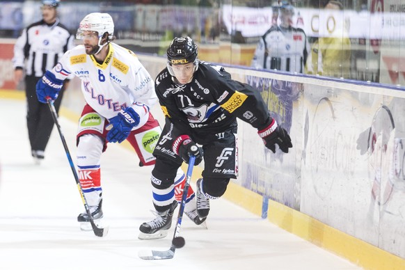 Le joueur de Kloten Roman Schlagenhauf, gauche, lutte pour le puck avec l&#039;attaquant fribourgeois Killian Mottet, droite, lors du match du championnat suisse de hockey sur glace de National League ...