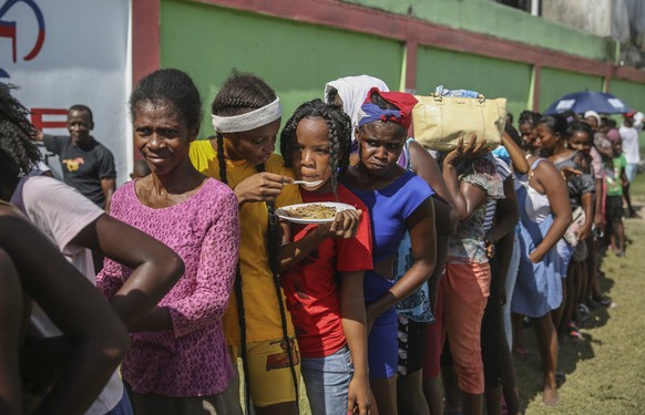 Residents line up during food distribution at a camp for residents displaced by the earthquake in Les Cayes, Haiti, Monday, Aug. 16, 2021, two days after a 7.2-magnitude earthquake struck the southwes ...