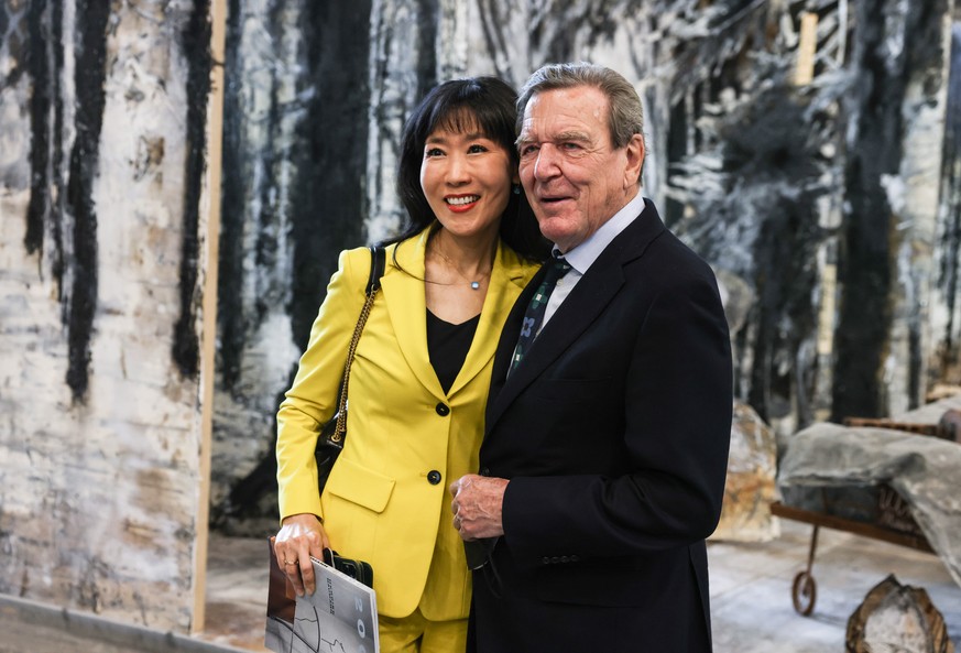 epa09254822 Former German Chancellor Gerhard Schroder (R) and his wife Soyeon Schroeder-Kim pose for photos as they visits the exhibition &#039;Diversity United&#039; at the former Tempelhof airport,  ...