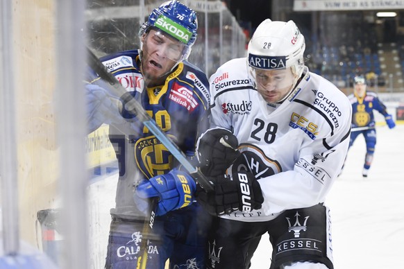 Davos&#039; Enzo Corvi, links, gegen Luganos Paul Postma, beim Eishockey-Qualifikationsspiel der National League A zwischen dem HC Davos und dem HC Lugano, am Dienstag, 19. November 2019, im Eisstadio ...