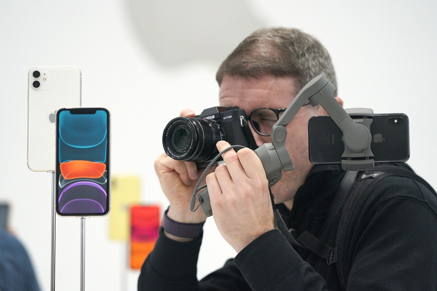 An event attendee takes a photo of the new Apple iPhone 11 that was on display during an event to announce new products Tuesday, Sept. 10, 2019, in Cupertino, Calif. (AP Photo/Tony Avelar)