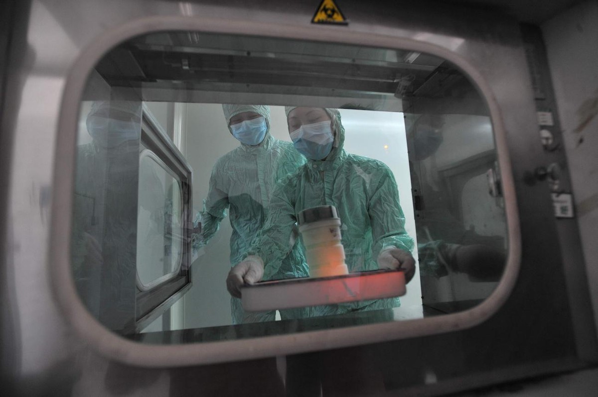 Researchers work with a sample of H1N1 flu virus at a lab in Wuhan, central China's Hubei province, Wednesday, June 17, 2009. Dozens of American high school students quarantined in a central Chin ...