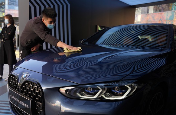 A workers wipes the hood of a car during a promotion held in a popular shopping district in Beijing on Sunday, Nov. 8, 2020. China&#039;s sales of vehicles including trucks and buses rose 12.5% over a ...