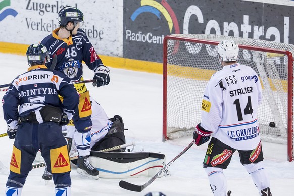 Zugs David McIntyre, Zugs Carl Klingberg und Fribourgs Ralph Stadler, von links, waehrend dem Eishockey-Meisterschaftsspiel der National League A zwischen dem EV Zug und dem Fribourg-Gotteron am Samst ...