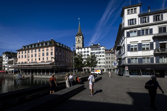 Personen gehen ueber die Zuercher Rathausbruecke, auch Gemuesebruecke genannt, am Dienstag, 9. Juli 2024 in Zuerich. (KEYSTONE/Michael Buholzer)