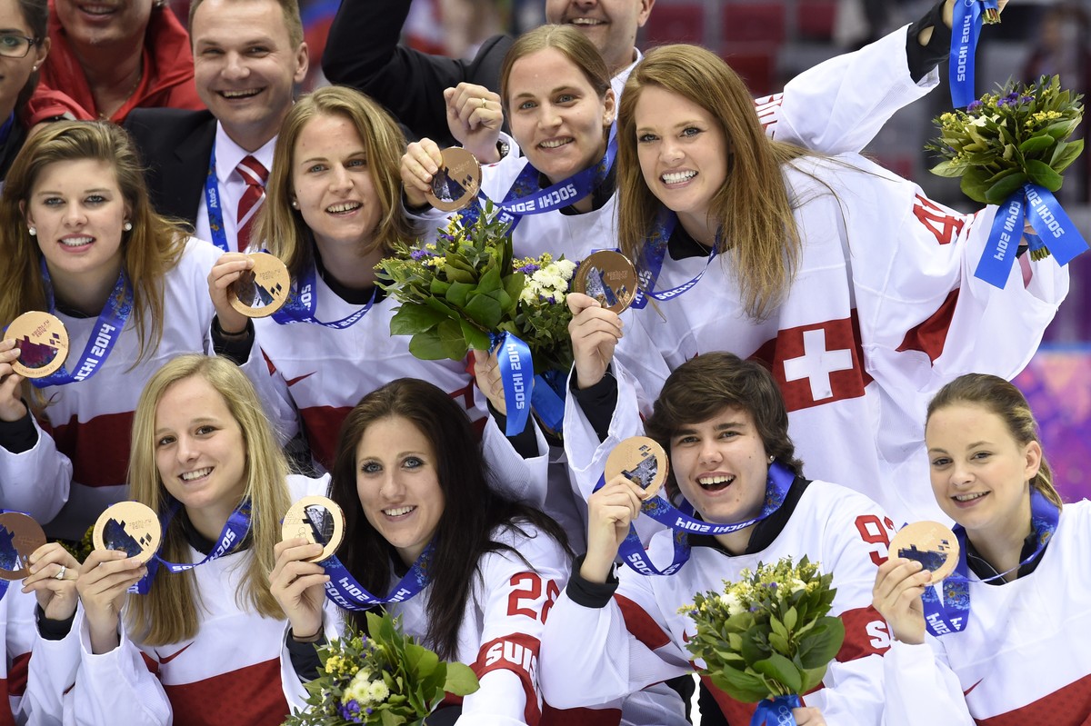 Switzerland's ice hockey women goalkeeper Florence Schelling, right up, and teamates celebrate their bronze medal during the women's ice hockey victory ceremony at the XXII Winter Olympics 2 ...