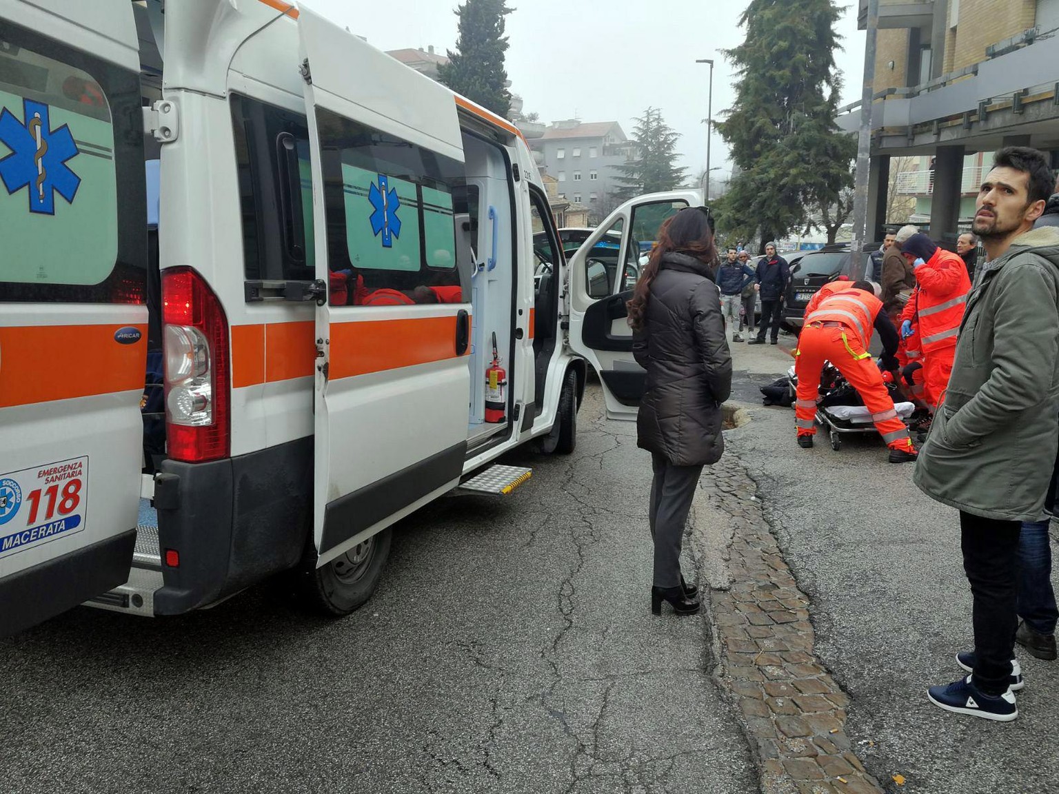 epa06493402 Paramedics treat an injured person that was shot from a passing vehicle in Macerata, Italy, 03 February 2018. According to the local authorities, the town at the eastern Italian coast near ...
