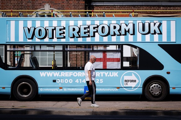 epa13150080 A person walks past a Reform UK campaign bus outside Clacton station in Clacton-on-Sea, Essex, Britain, 04 August 2026. Reform UK leader Nigel Farage will contest the Clacton by-election o ...
