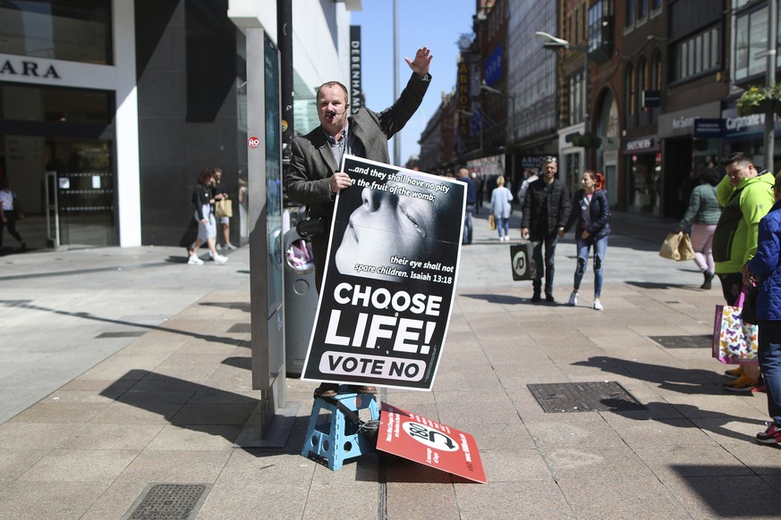 In this May 17, 2018 photo, an anti abortion campaigner holds up a banner as he speaks, in Dublin, Ireland ahead of the abortion referendum on Friday, May 25. An abortion debate that has inflamed pass ...