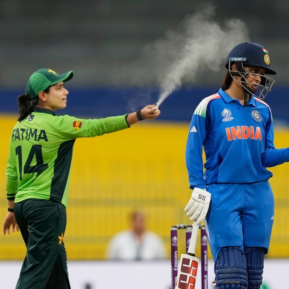 Pakistan&#039;s captain Fatima Sana sprays insect repellent to ward off bugs flying over the pitch during the ICC Women&#039;s Cricket World Cup match between India and Pakistan at Premadasa Stadium i ...