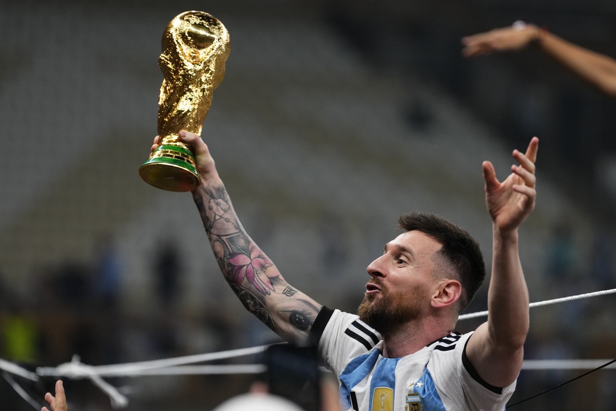 Argentina's Lionel Messi celebrates with the trophy after winning the World Cup final soccer match between Argentina and France at the Lusail Stadium in Lusail, Qatar, Sunday, Dec.18, 2022. (AP P ...