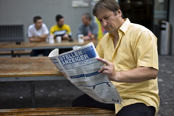 Ein Arbeitsloser liest am 20. August 2010 am Hauptbahnhof in Zuerich den Stellenanzeiger. (KEYSTONE/Martin Ruetschi) === GESTELLTE AUFNAHME ===