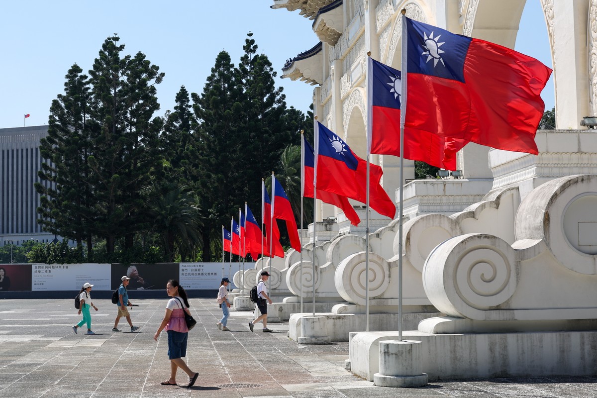 epa13297940 People walk past Taiwan flags in Taipei, Taiwan, 12 October 2026. Taiwan's Defense Minister Wellington Koo said the country is monitoring China's military exercises scheduled for ...