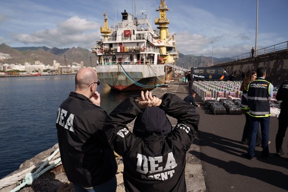 epa12644603 DEA agents watch drug packages found in the cargo vessel seized by Spanish police and the Spanish Navy 535 km off the coast of the Canary Islands arrives at the port of Santa Cruz de Tener ...