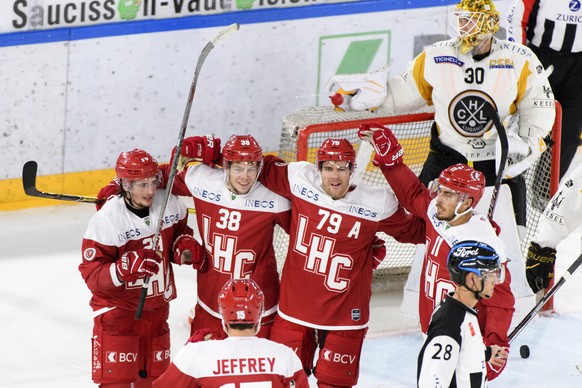 De gauche a droite, les joueurs lausannois Axel Simic, Lukas Frick, Joel Genazzi et Yannick Herren celebrent le deuxieme goal devant la deception le gardien luganais Elvis Merzlikins, droite, lors de  ...