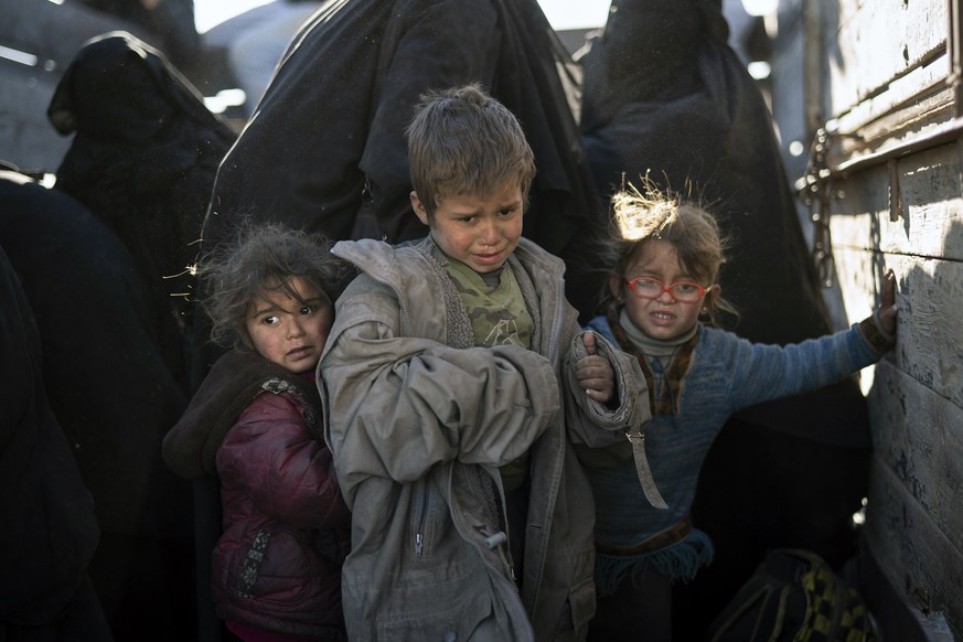 Women and children exit the back of a truck as they arrive to a U.S.-backed Syrian Democratic Forces (SDF) screening area after being evacuated out of the last territory held by Islamic State militant ...