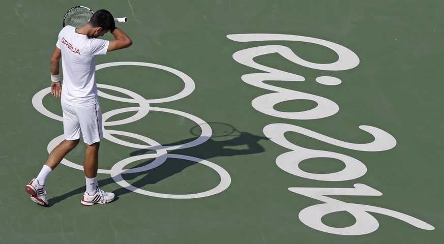 Novak Djokovic, of Serbia, wipes his brow as he practices on center court prior to the 2016 Summer Olympics in Rio de Janeiro, Brazil, Thursday, Aug. 4, 2016. (AP Photo/Charles Krupa)