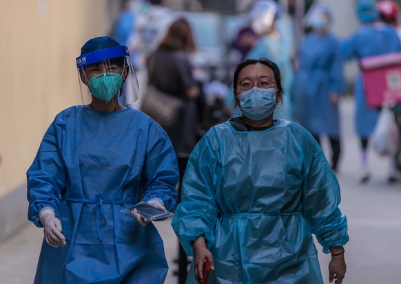 epa09820612 Medical personal walk in the makeshift Covid-19 testing site in residential compound, in Shanghai, China, 13 March 2022. According to the National Health Commission, on 13 March 2022, Chin ...