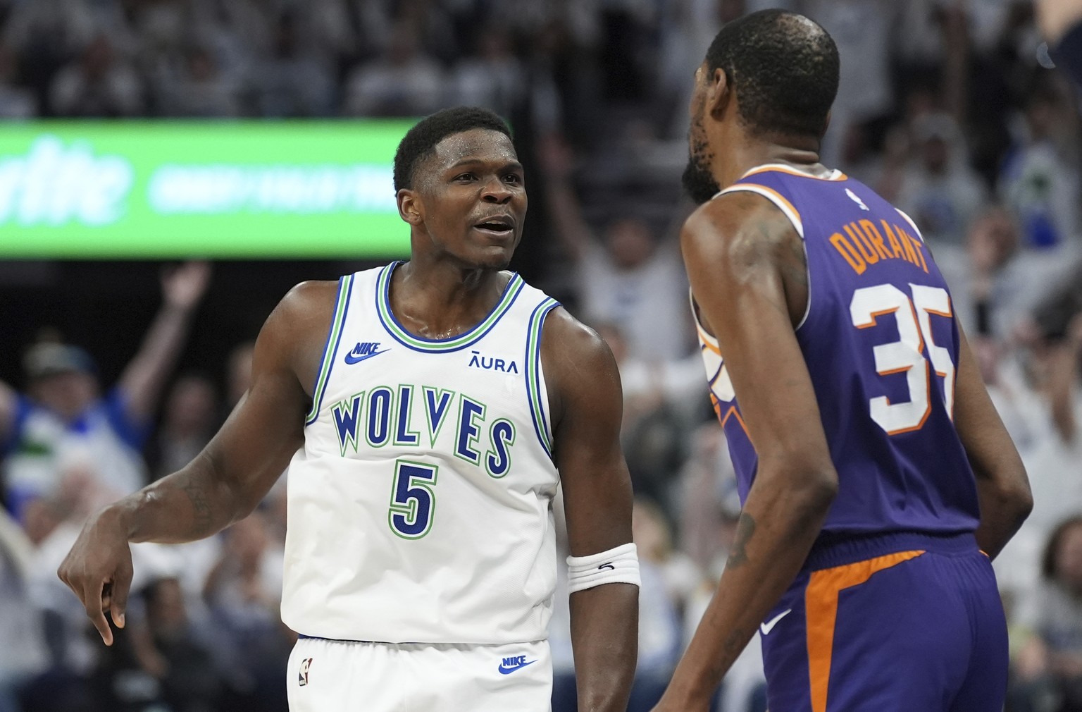 Minnesota Timberwolves guard Anthony Edwards (5) celebrates toward Phoenix Suns forward Kevin Durant (35) after making a 3-point shot during the second half of Game 1 of an NBA basketball first-round  ...