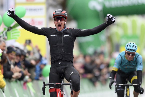 Stefan Kueng, left, from Switzerland of team BMC Racing raises his arms after crossing the finish line to win the second stage in front of second placed Ukrainian Andriy Grivko, right, of team Astana, ...