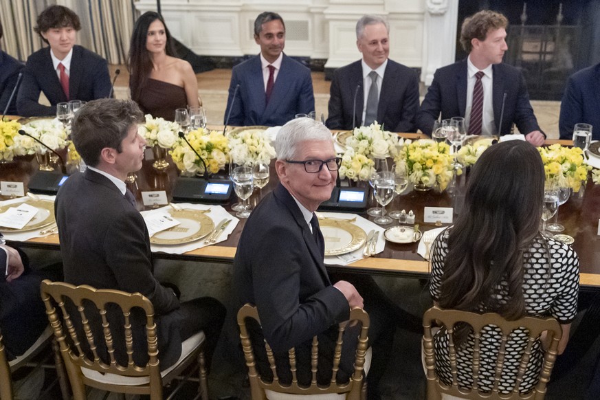 Tim Cook, CEO of Apple, turns around before President Donald Trump speaks during a dinner in the State Dinning Room of the White House, Thursday, Sept. 4, 2025, in Washington. At left is OpenAI CEO Sa ...