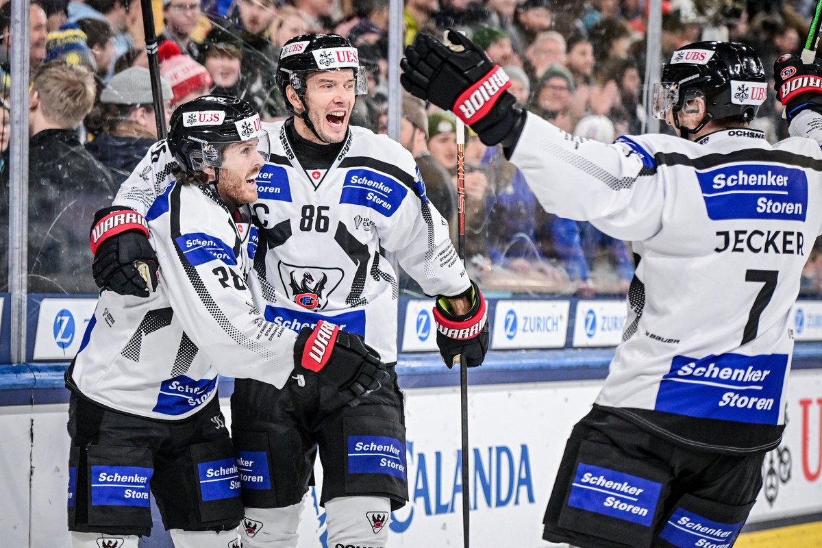 epa11799828 Fribourg's Christoph Bertschy (L) celebrates after scoring the 1-4 goal during the Spengler Cup 2024 final game between Straubing Tigers and HC Fribourg-Gotteron, at the 96th Spengler ...