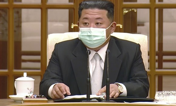 In this image made from video broadcasted by North Korea&#039;s KRT, North Korean leader Kim Jong Un wears a face mask on state television during a meeting acknowledging the country&#039;s first case  ...