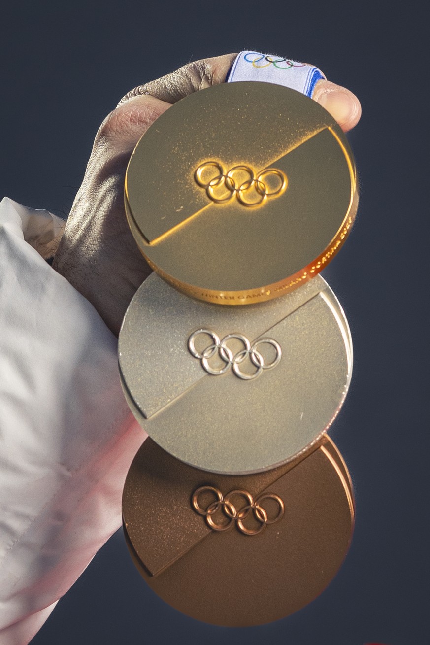 Gold medalist Switzerland's Loic Meillard presents his medals after the men's alpine skiing slalom race at the 2026 Olympic Winter Games at the Stelvio Ski centre in Bormio, Italy, on Monday ...