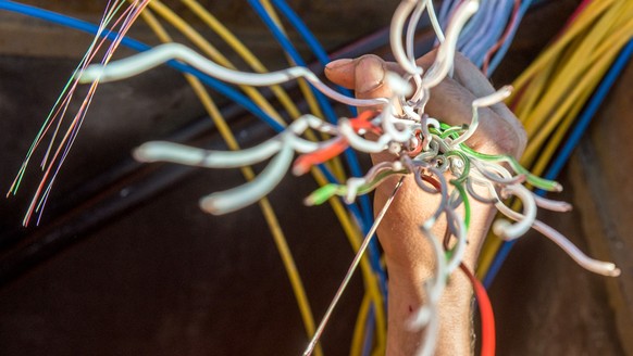 Ein Arbeiter zeigt Glasfaserkabel der Swisscom fuer den Internetansschluss von Privathaushalten, am Dienstag, 10. Februar 2015 in Bellinzona. Die staedtischen Betriebe Bellinzona "Aziende Municip ...