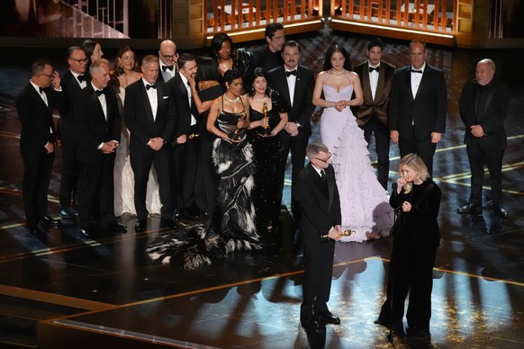 Paul Thomas Anderson, left center, Sara Murphy, right center, and the team from "One Battle After Another" accept the award for best picture during the Oscars on Sunday, March 15, 2026, at t ...